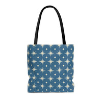 Photo of a blue tote bag and a star tote bag that features a repeating pattern of cream colored stars against a slate blue background, in a minimalist style that also resembles a Scandinavian tote bag style.